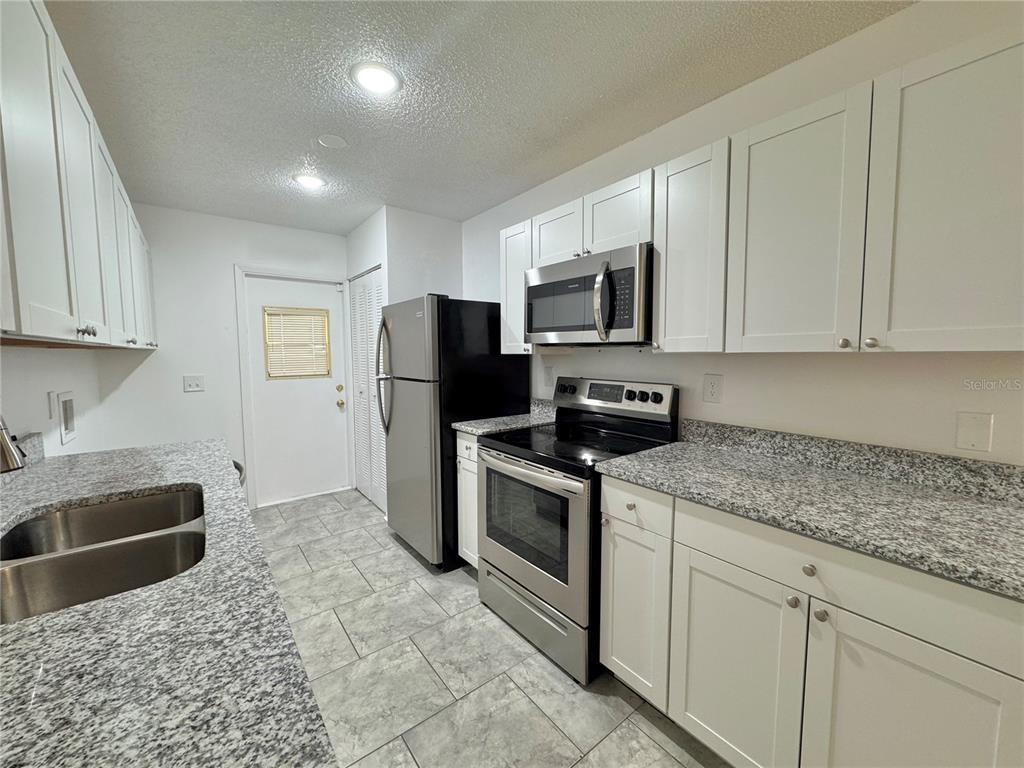 292 Winter Ridge Boulevard, Unit 292 Winter Haven, FL 33881 - Photo 6 of 37 a kitchen with stainless steel appliances granite countertop a stove a sink and a refrigerator