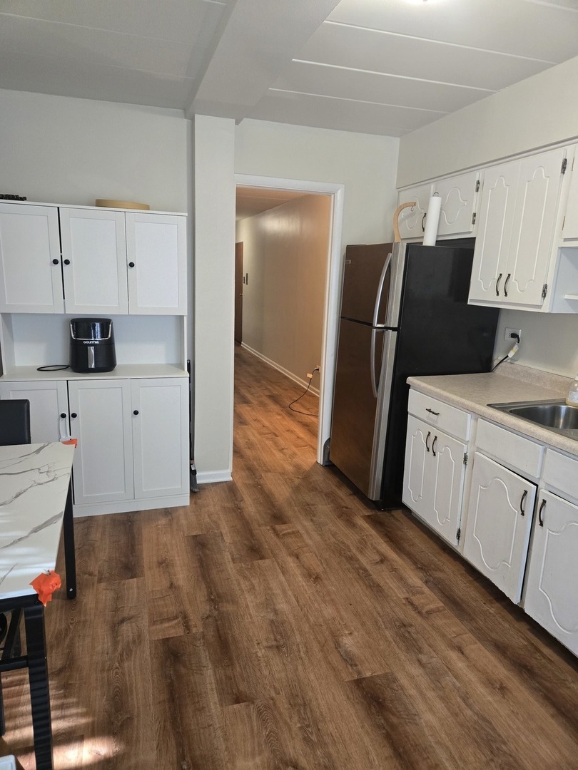 1141 Leavitt Avenue, Unit 115 Flossmoor, IL 60422 - Photo 9 of 18 a kitchen with granite countertop white cabinets and refrigerator
