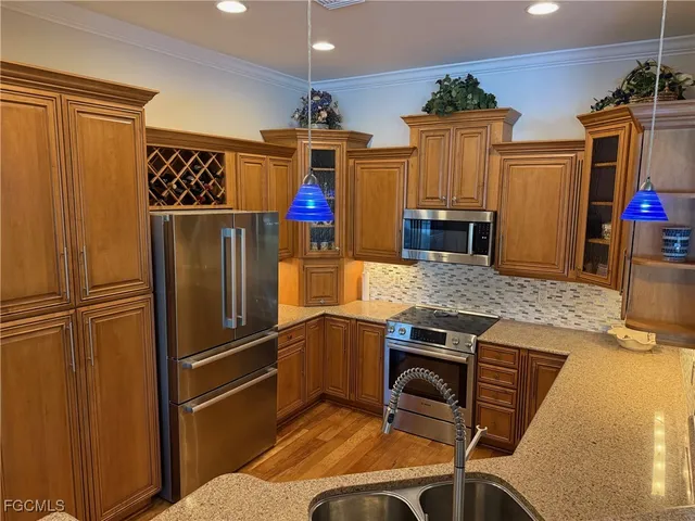 a kitchen with stainless steel appliances granite countertop a refrigerator and a stove