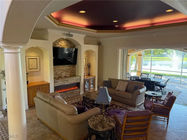 a living room with fireplace furniture and a large window