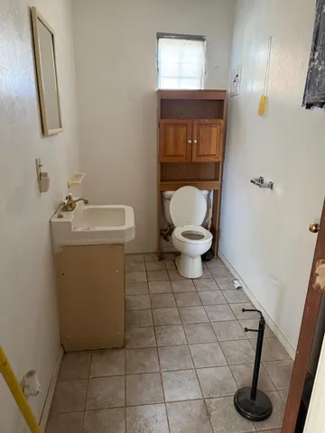 a bathroom with a toilet sink and mirror