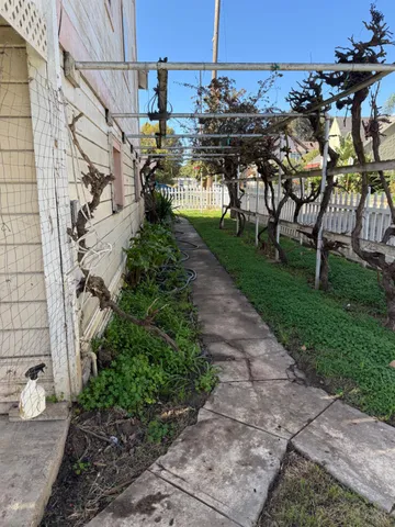a view of a house with a small yard and wooden fence