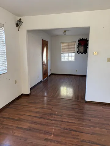 a view of a living room with hardwood floor and a ceiling fan