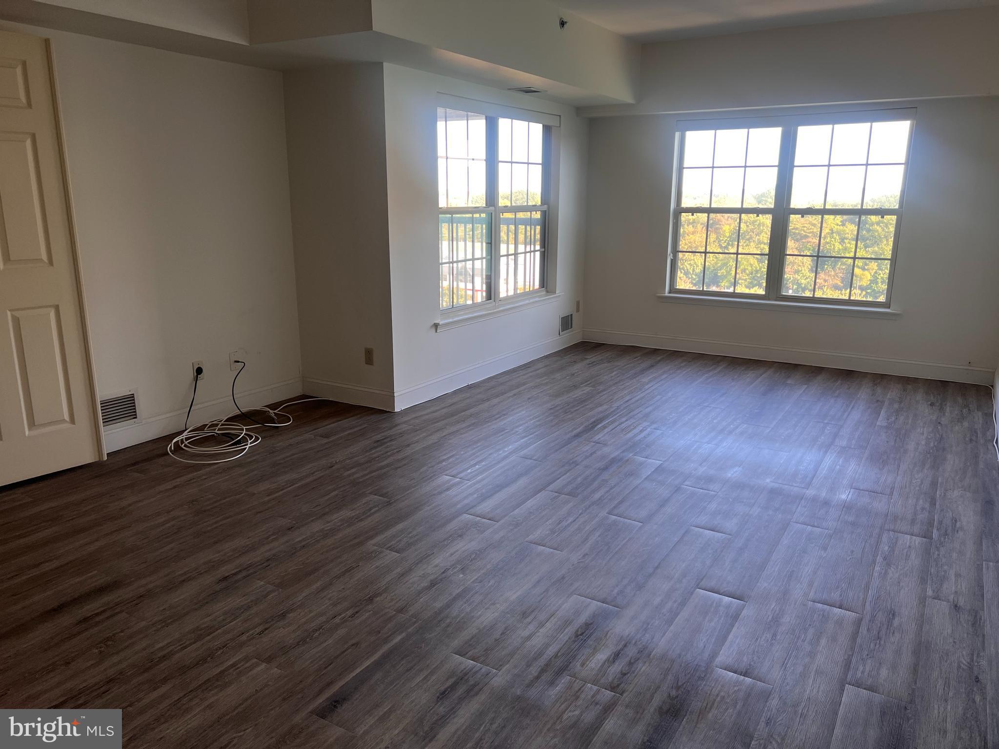 6073 Main Street Voorhees, NJ 08043 - Photo 5 of 16 an empty room with wooden floor and windows