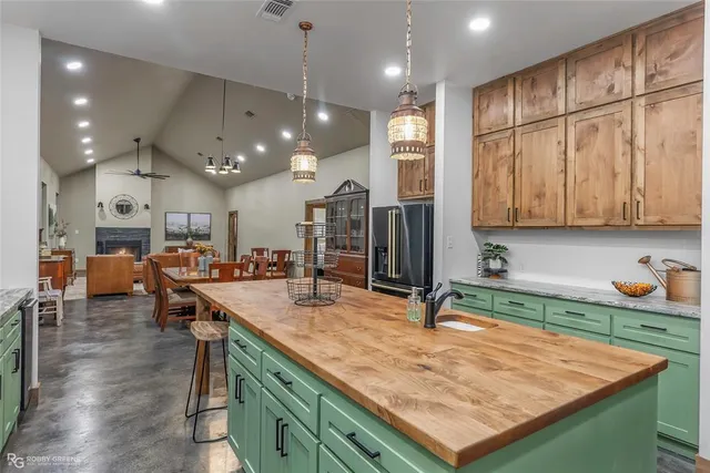 a kitchen with kitchen island granite countertop a wooden cabinets and stainless steel appliances