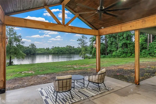 a patio with water view fountain and a yard
