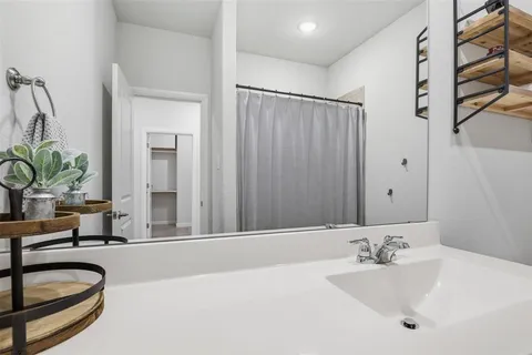 a bathroom with a granite countertop sink and a large mirror