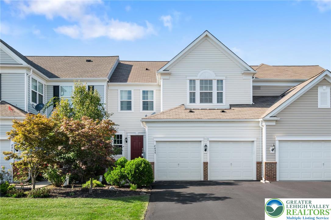 8455 Starling Road Breinigsville, PA 18031 - Photo 1 of 24 Well-maintained townhome with a double garage, featuring mature landscaping and a welcoming entrance.