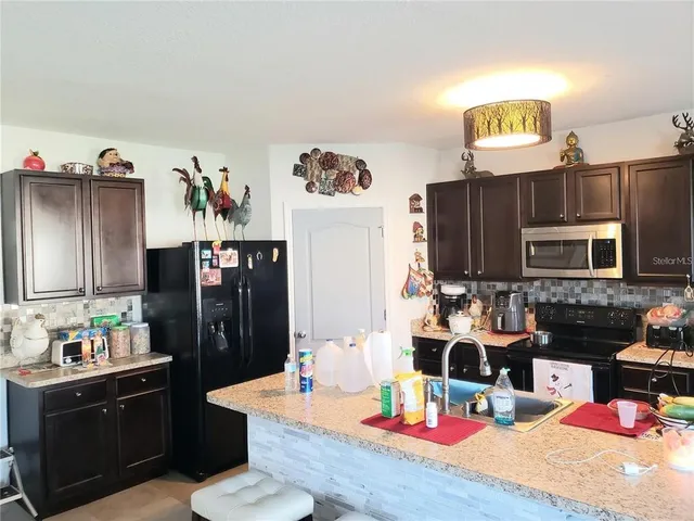 a kitchen with a refrigerator and a stove top oven