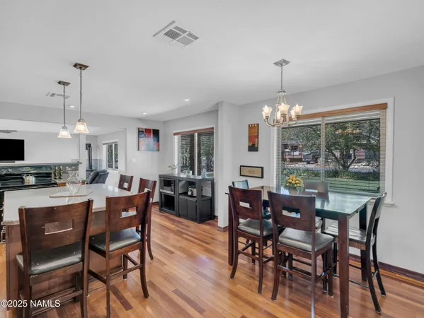 a kitchen with stainless steel appliances granite countertop a stove top oven a refrigerator a sink and chairs