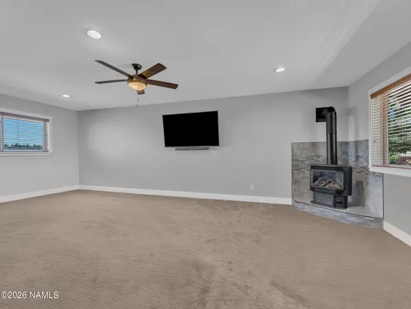 an empty room with window and a flat screen tv