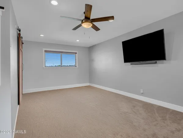 a bedroom with a large bed and a large mirror