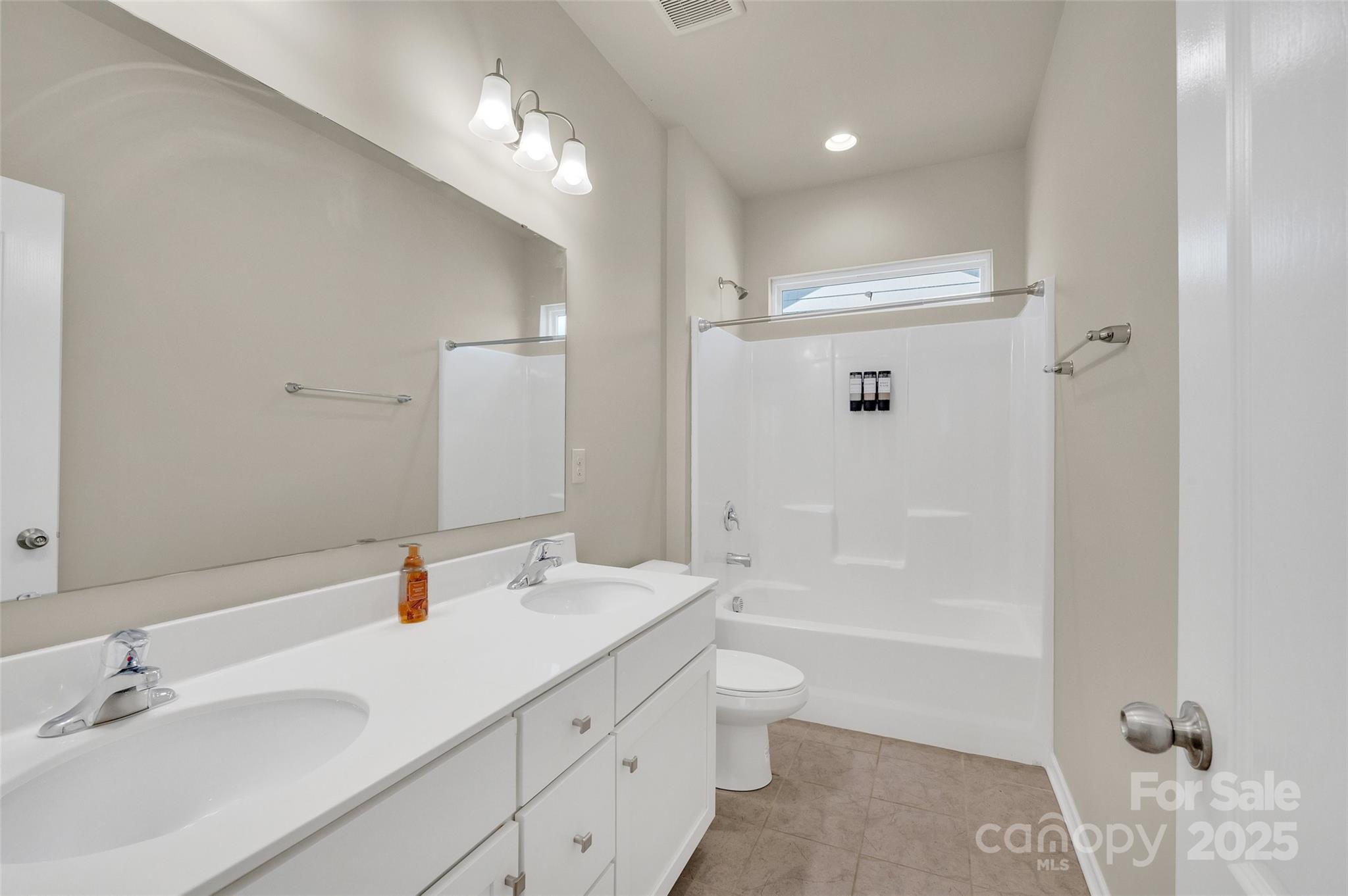 6130 Cloverdale Drive Tega Cay, SC 29708 - Photo 23 of 39 a bathroom with a bathtub shower sink double vanity and a mirror