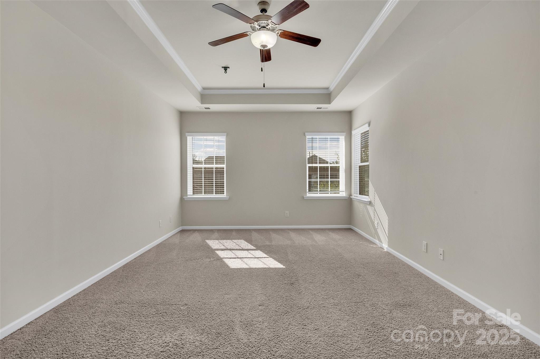 6130 Cloverdale Drive Tega Cay, SC 29708 - Photo 27 of 39 an empty room with chandelier fan and windows