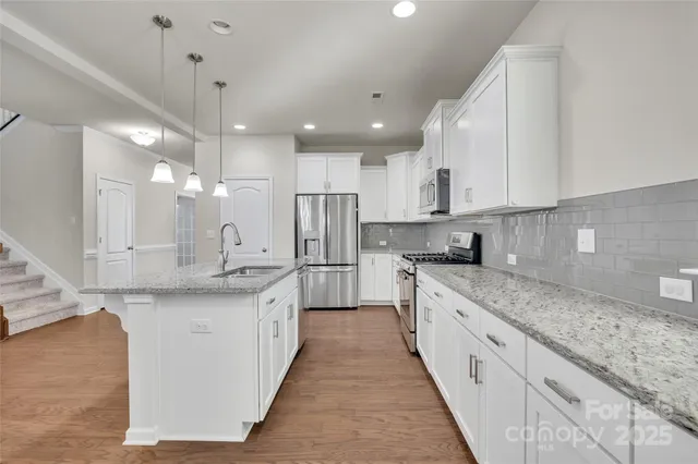 a large kitchen with stainless steel appliances lots of counter space sink and cabinets