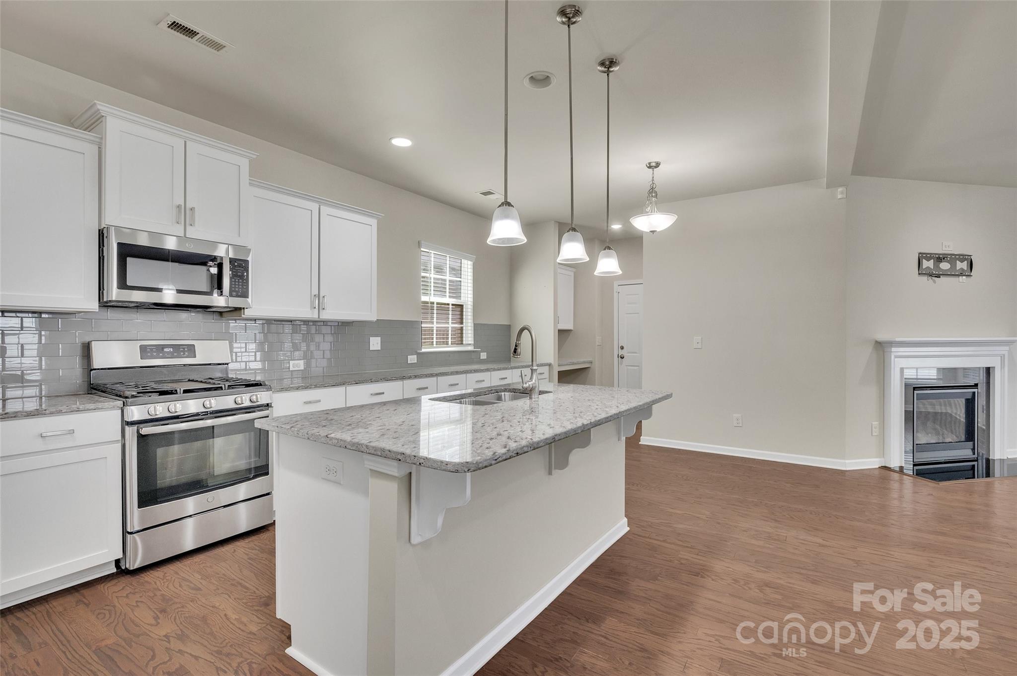 6130 Cloverdale Drive Tega Cay, SC 29708 - Photo 8 of 39 a large kitchen with kitchen island a stove a sink a center island and wooden floor