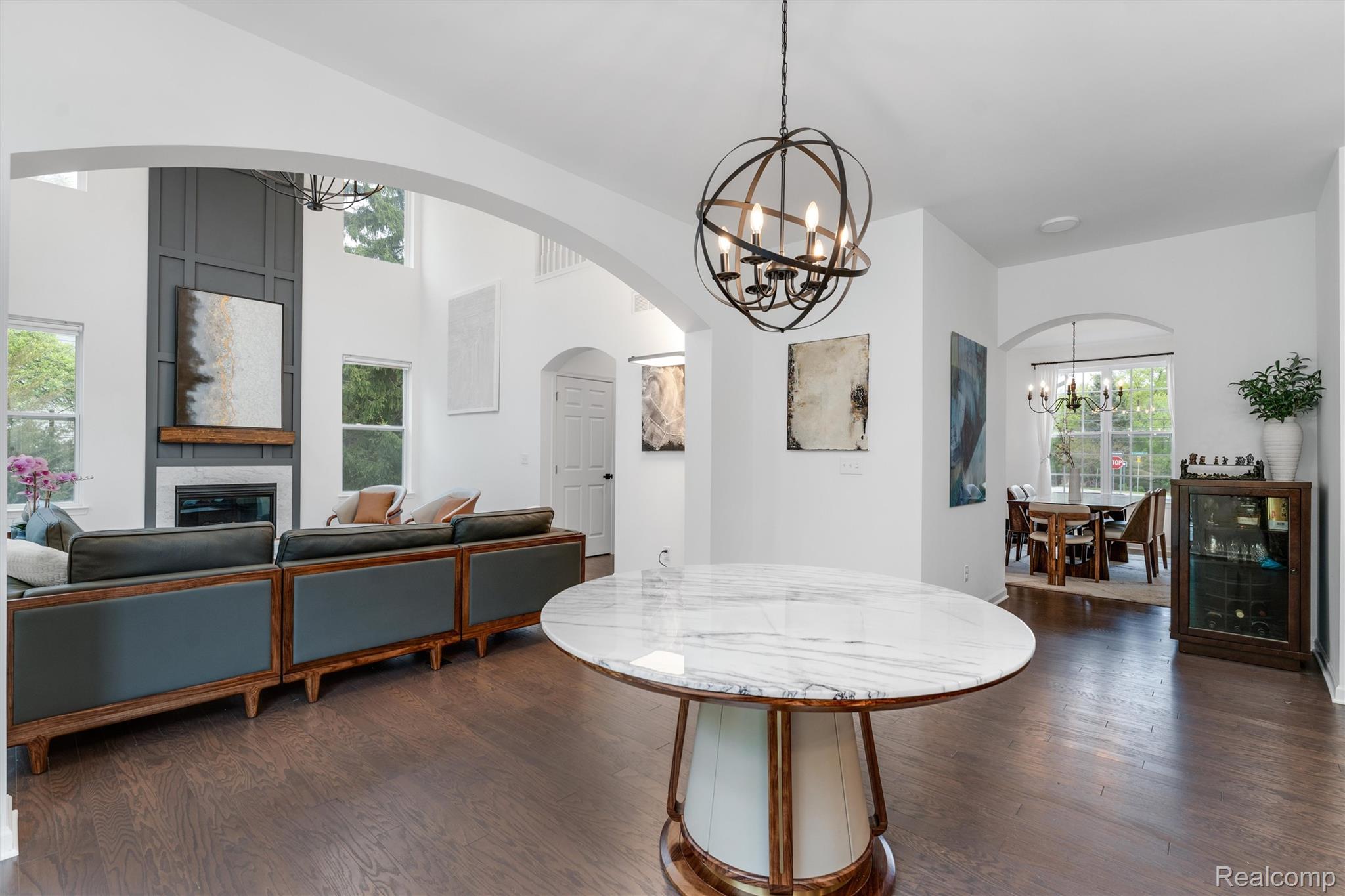 908 South Livernois Road Rochester, MI 48309 - Photo 10 of 49 Dining area featuring a chandelier, arched walkways, dark wood-style flooring, and a fireplace