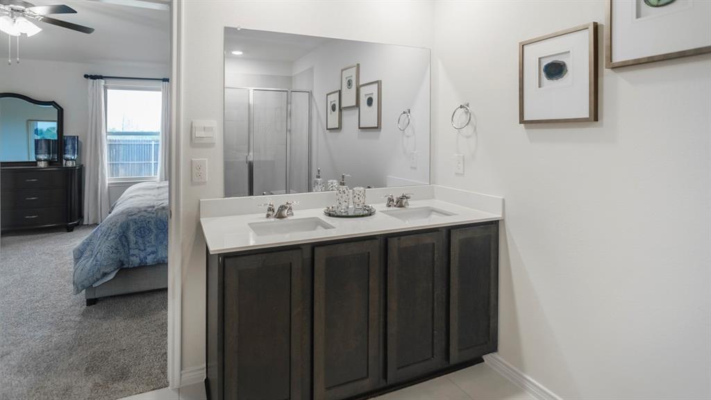 504 Carthage Street Caddo Mills, TX 75135 - Photo 11 of 17 a en suite bathroom with a double vanity sink and a mirror
