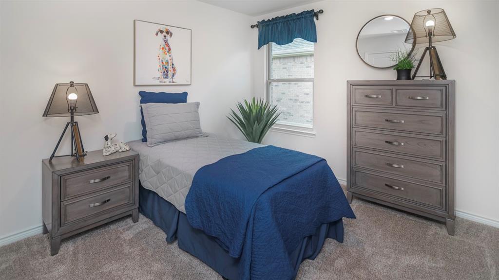 504 Carthage Street Caddo Mills, TX 75135 - Photo 3 of 17 a bedroom with a bed and a chandelier