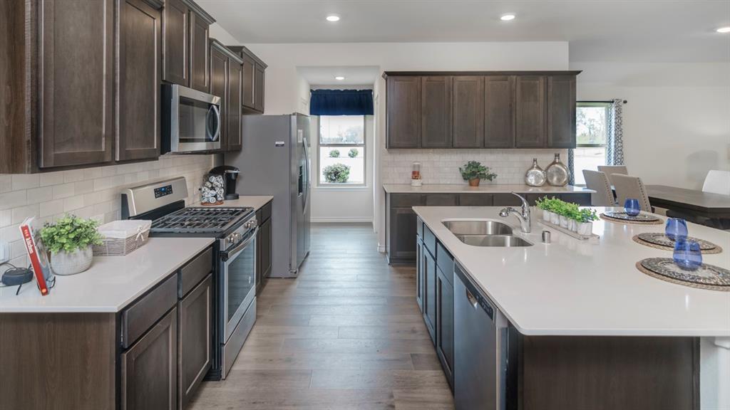 504 Carthage Street Caddo Mills, TX 75135 - Photo 5 of 17 a kitchen with stainless steel appliances granite countertop a sink stove and refrigerator