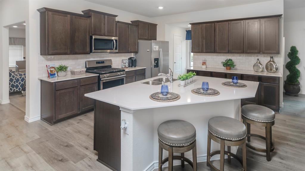 504 Carthage Street Caddo Mills, TX 75135 - Photo 6 of 17 a kitchen with a dining table and chairs