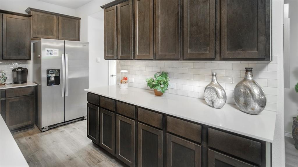 504 Carthage Street Caddo Mills, TX 75135 - Photo 8 of 17 a kitchen with stainless steel appliances a refrigerator and cabinets