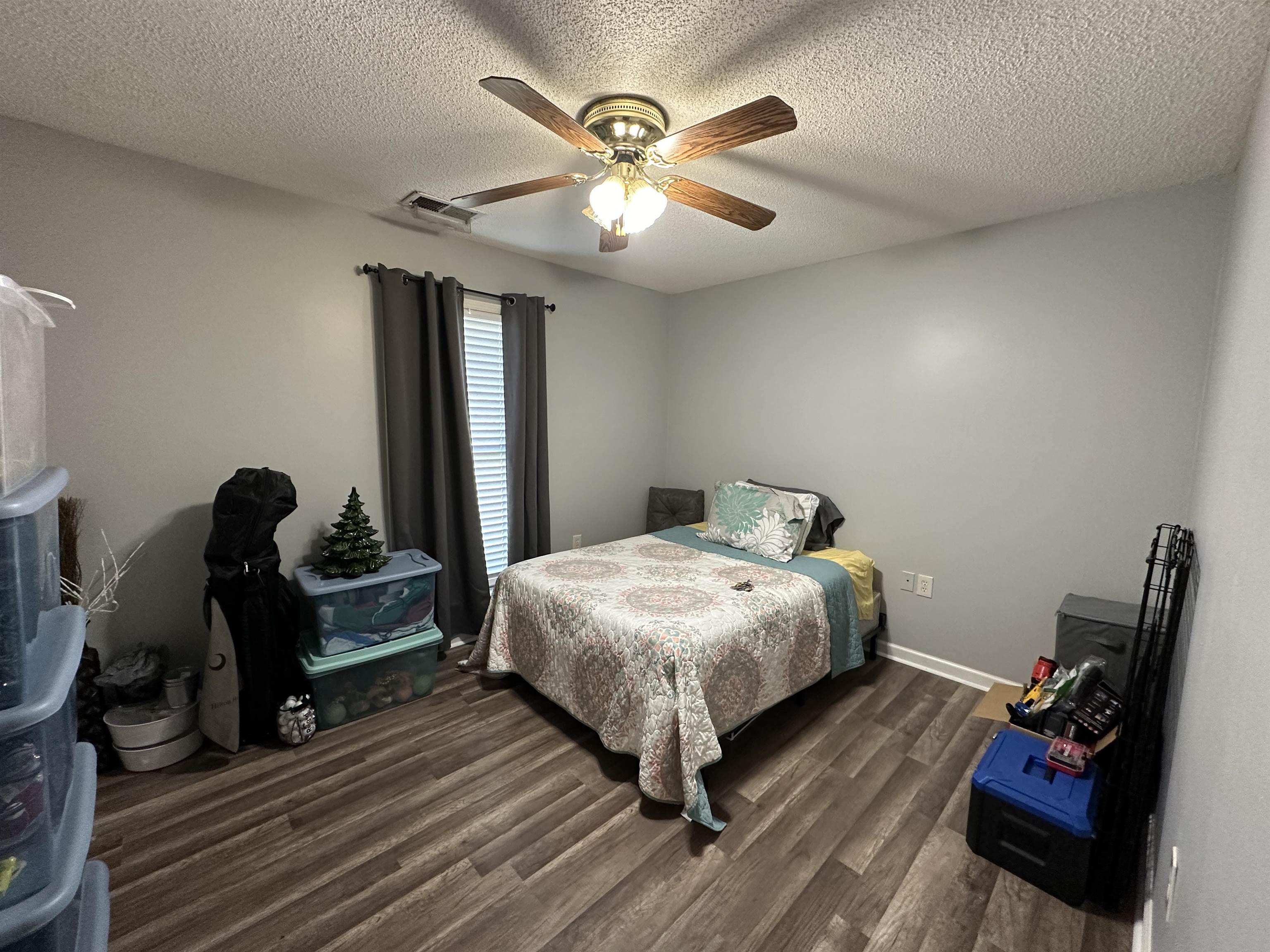 170 Lee Street Brighton, TN 38011 - Photo 5 of 11 Bedroom featuring ceiling fan, dark wood-type flooring, a textured ceiling, visible vents, and baseboards