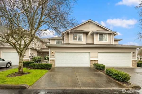 a front view of a house with a yard and garage