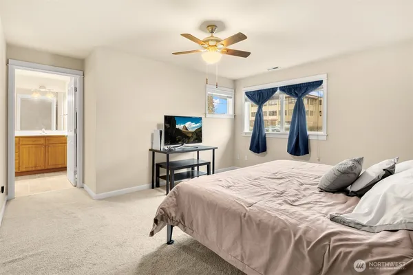 a bedroom with a bed and a flat tv screen on dresser
