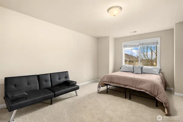 a bedroom with a bed couch and window