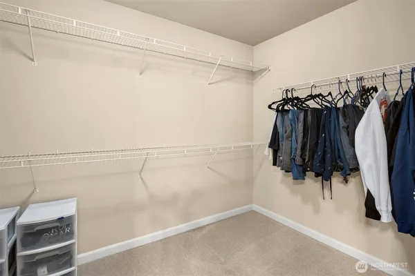 a view of walk in closet with clothes