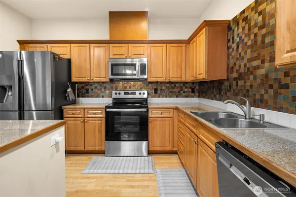 a kitchen with stainless steel appliances granite countertop a sink stove and refrigerator
