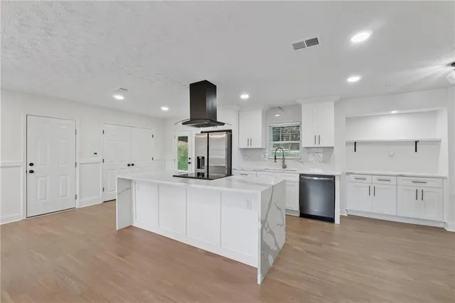 a kitchen with white cabinets and sink