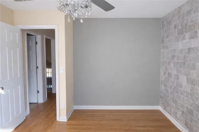 a view of a hallway with wooden floor and a chandelier