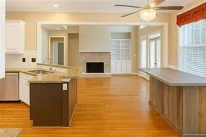 a kitchen with stainless steel appliances granite countertop a sink cabinets and a fireplace