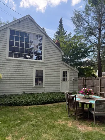 a view of a house with backyard and sitting area