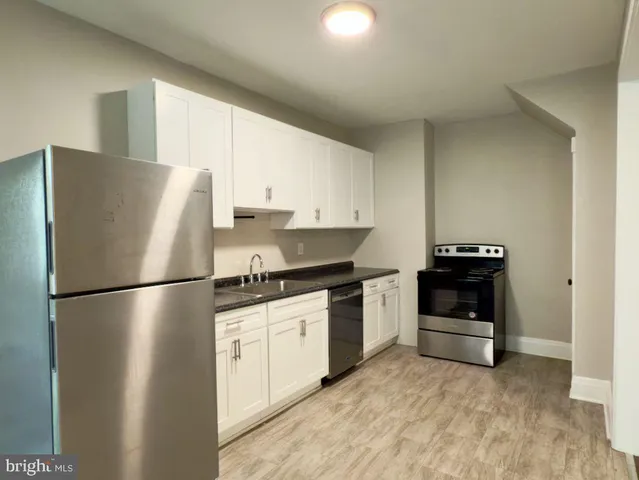 a white refrigerator freezer and a stove sitting inside of a kitchen