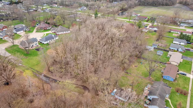 a aerial view of a residential apartment building with a yard and parking spaces
