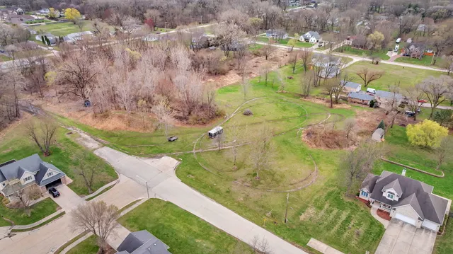 an aerial view of a house with a yard and lake view