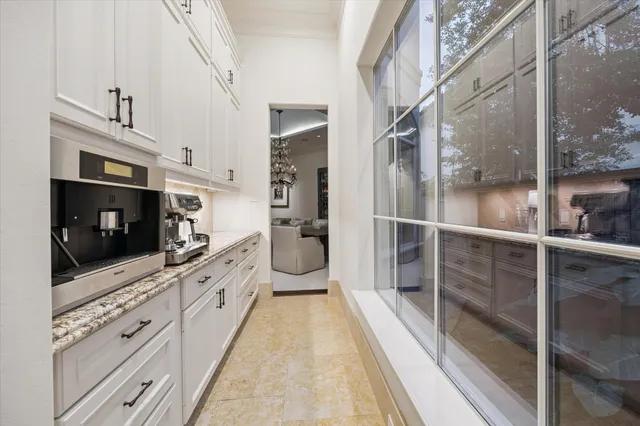 a large white kitchen with a large window and stainless steel appliances