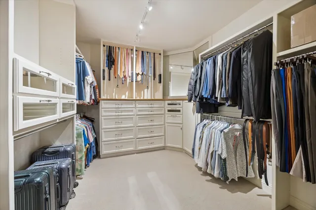 a view of walk in closet with clothes and shoes