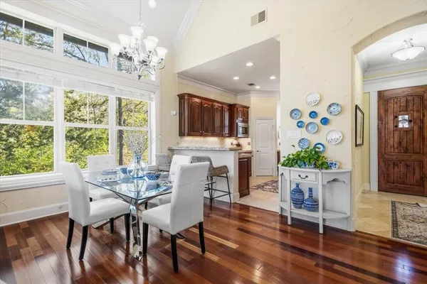 a view of a dining room with furniture a chandelier and wooden floor