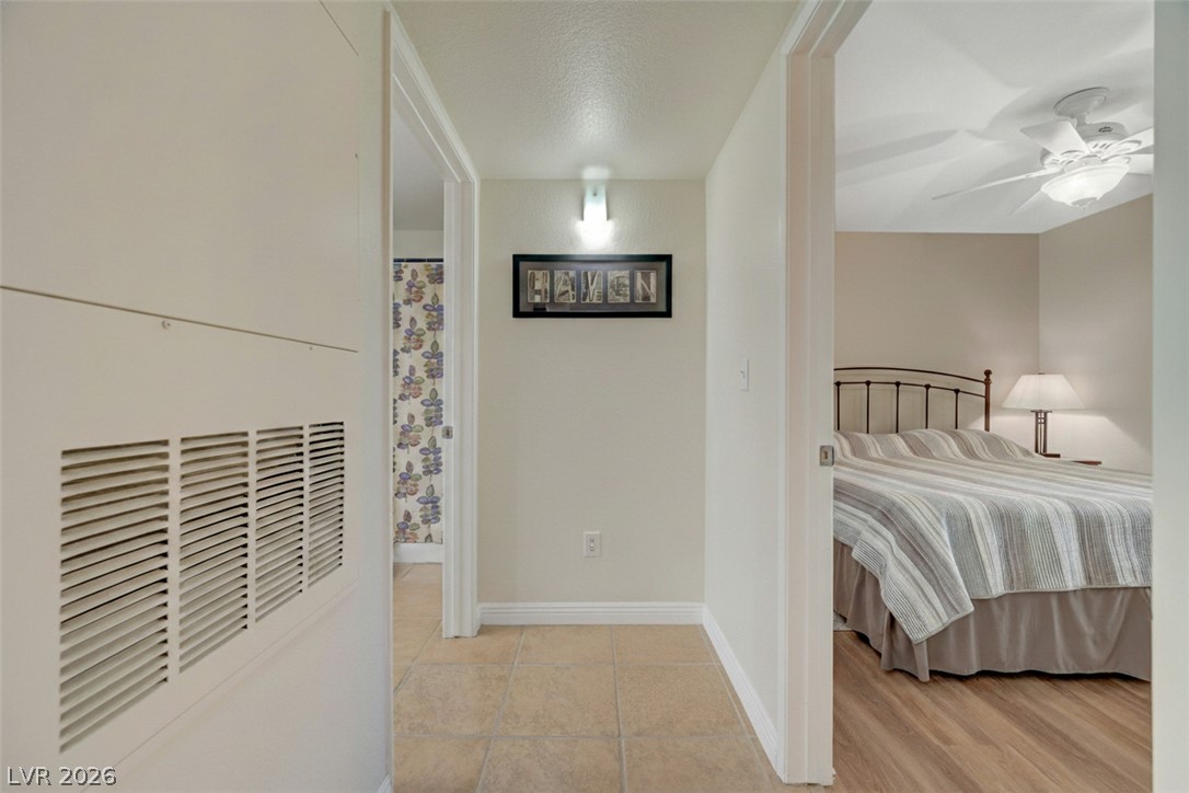 7885 West Flamingo Road, Unit 1071 Las Vegas, NV 89147 - Photo 17 of 28 Comfortable bedroom with wood-look flooring and a ceiling fan, offering a serene escape.