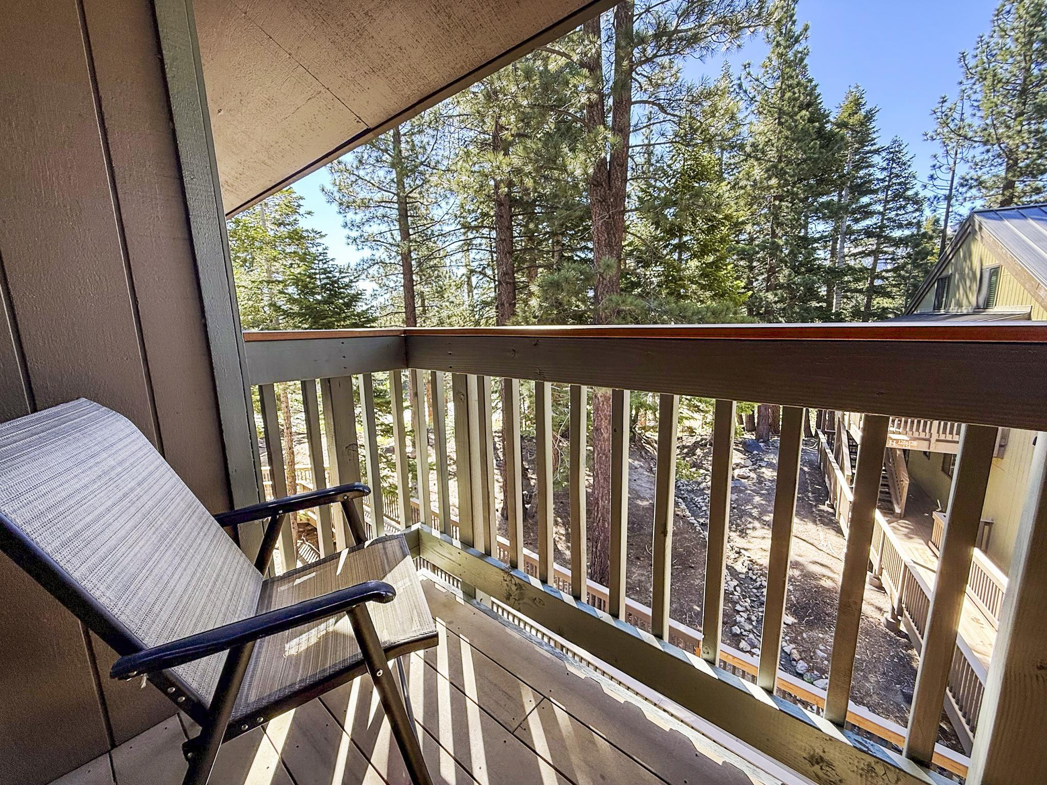 153 Lake Mary Road, Unit 114 Mammoth Lakes, CA 93546 - Photo 10 of 22 Private balcony featuring wood siding, wood-finish flooring, and a sturdy wood railing, surrounded by mature trees