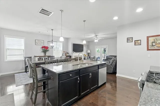 a kitchen with a stove a sink a dining table and chairs
