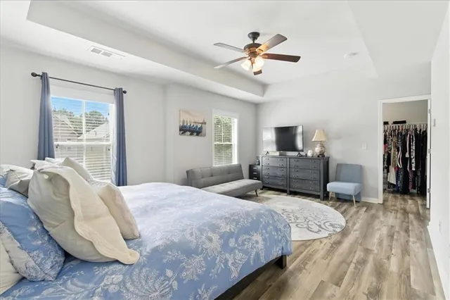 a spacious bedroom with a bed and wooden floor