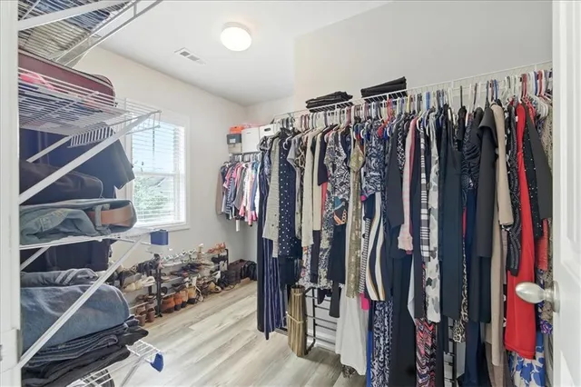 a view of walk in closet with clothes