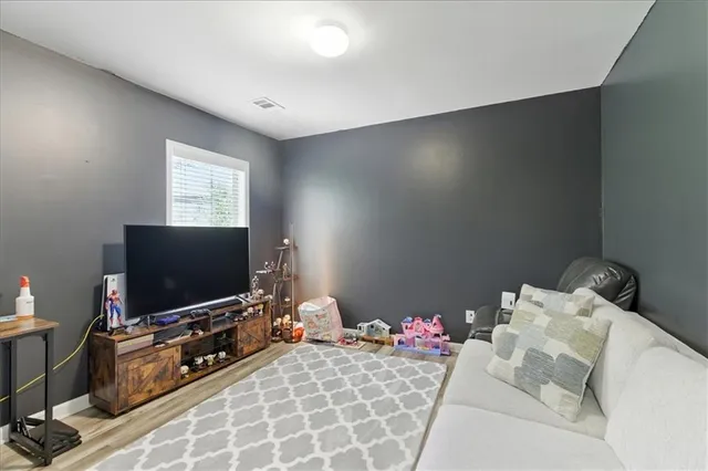 a bedroom with furniture and a flat screen tv