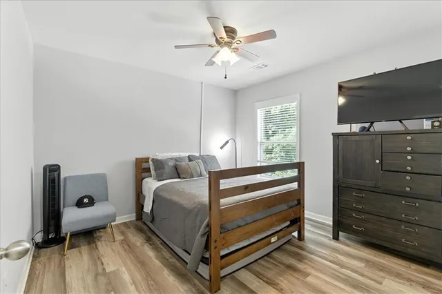 a bedroom with a bed and a flat tv screen on dresser
