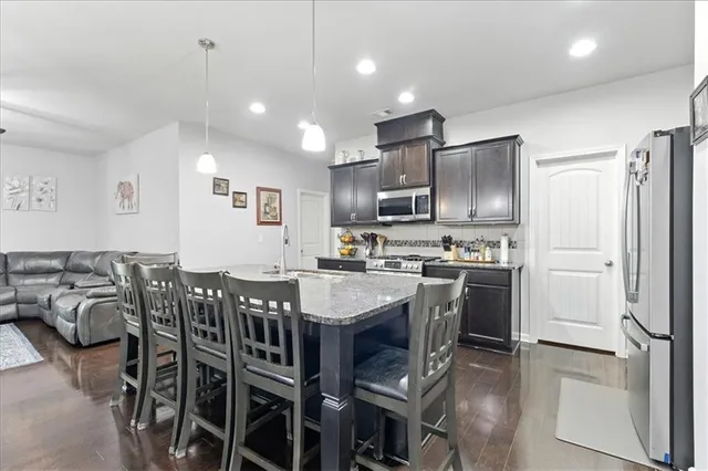 a large kitchen with a table chairs refrigerator and microwave